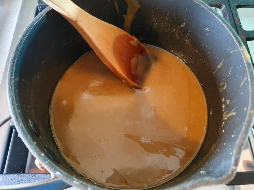 Stirring icing well in pot on stove.