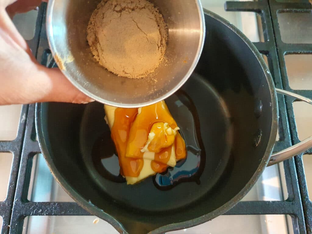 Adding ground ginger to pot on stove.