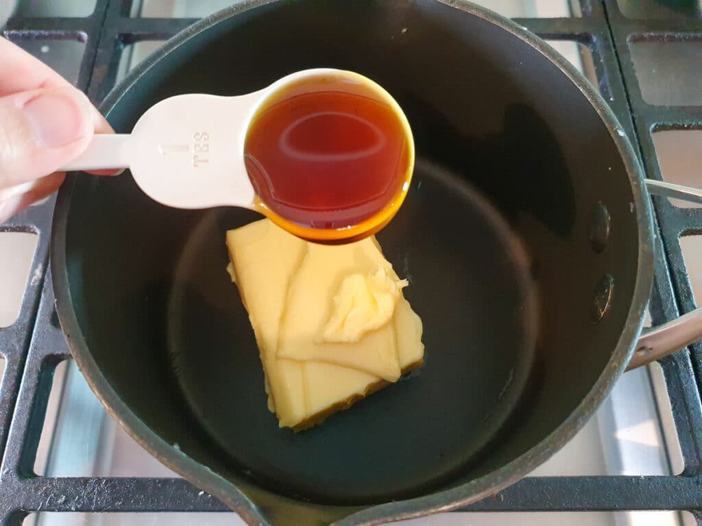 Adding golden syrup to pot on stove.