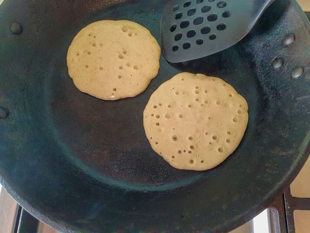 Banana pikelets 12 Pikelets with bubbles ready to flip.