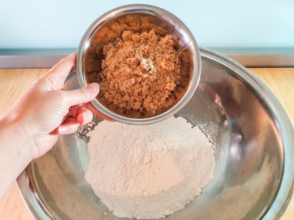 Adding brown sugar to flour.