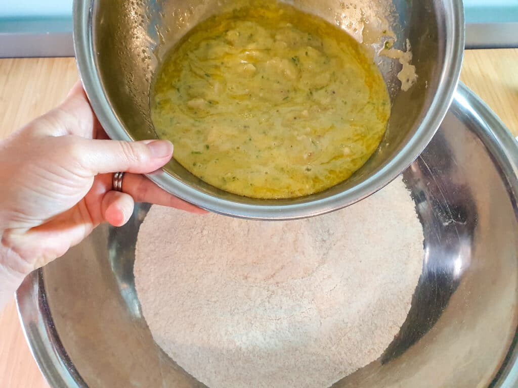 Adding wet ingredients to dry ingredients.