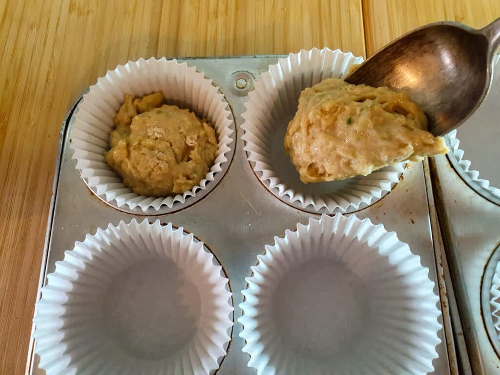 Spooning mix into muffin tins.