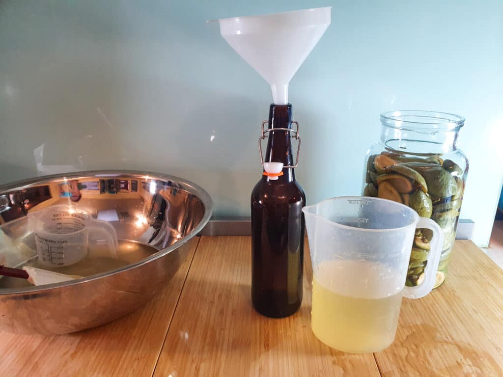 Pouring feijoa juice into bottled using a funnel after first brew.