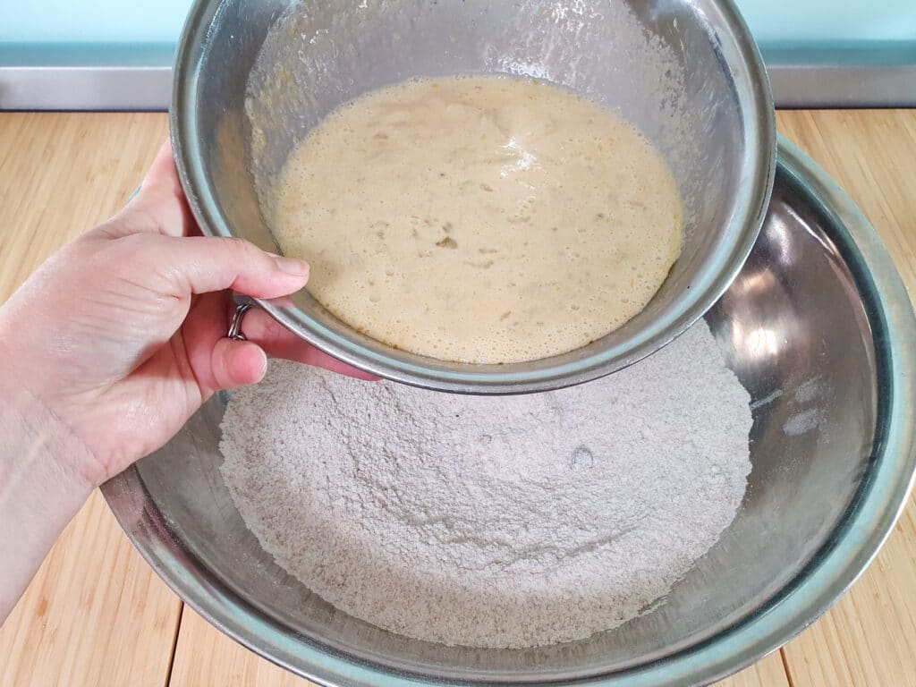 Adding wet ingredients to dry ingredients.