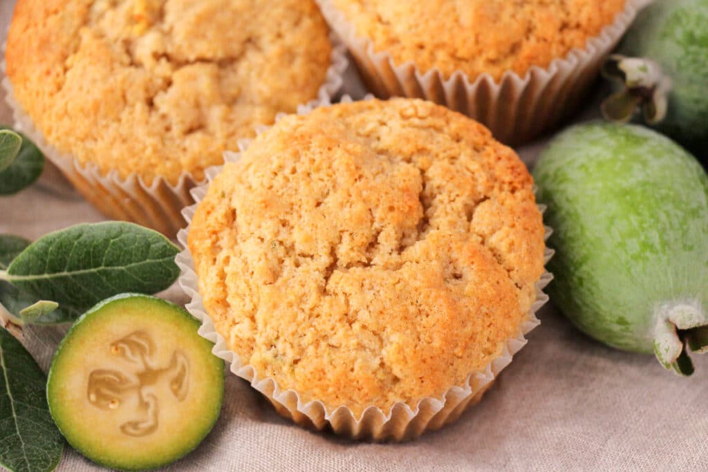 Feijoa muffins with fresh feijoas and feijoa leaves.