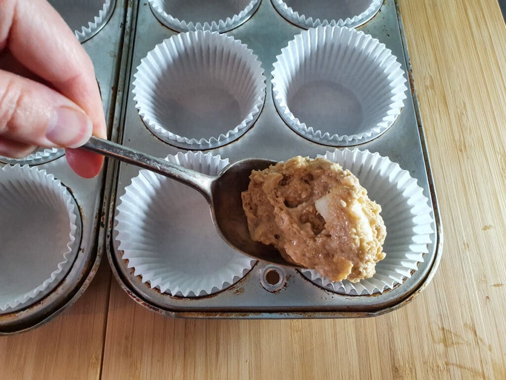Pear muffins 12 Spooning muffin batter into tins.