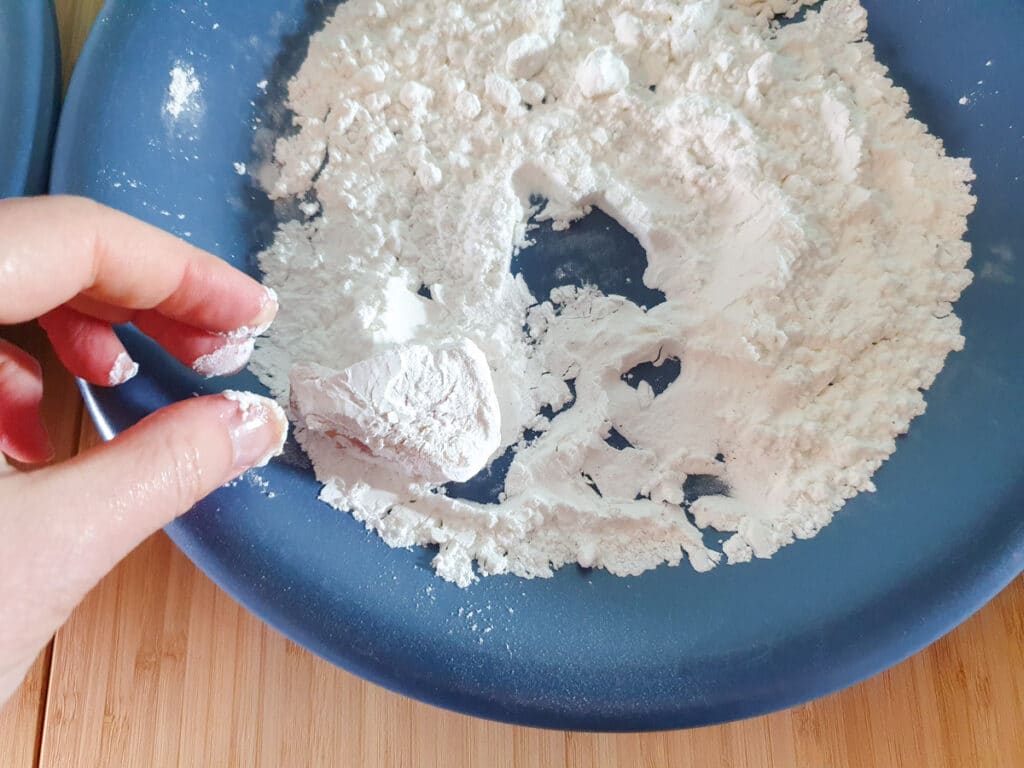Coating chicken in flour after egg wash.