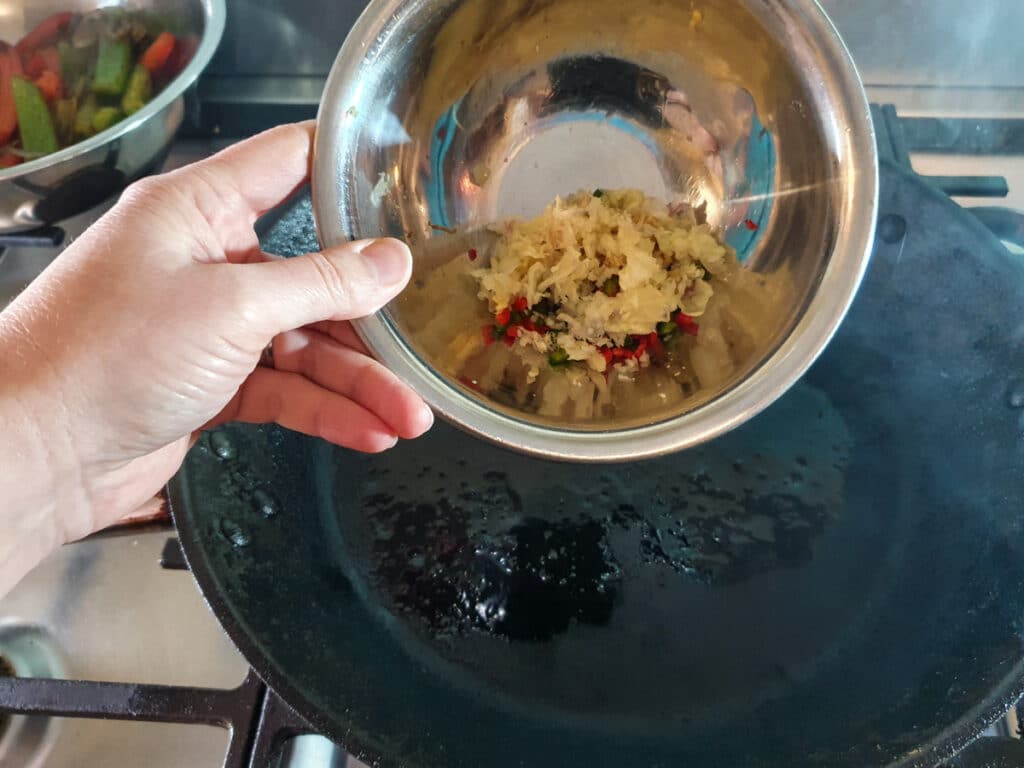 Adding garlic, chilli and ginger to the pan.