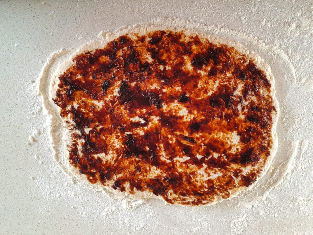 Cheesymite Scrolls 10 Dough with vegemite spread over it.
