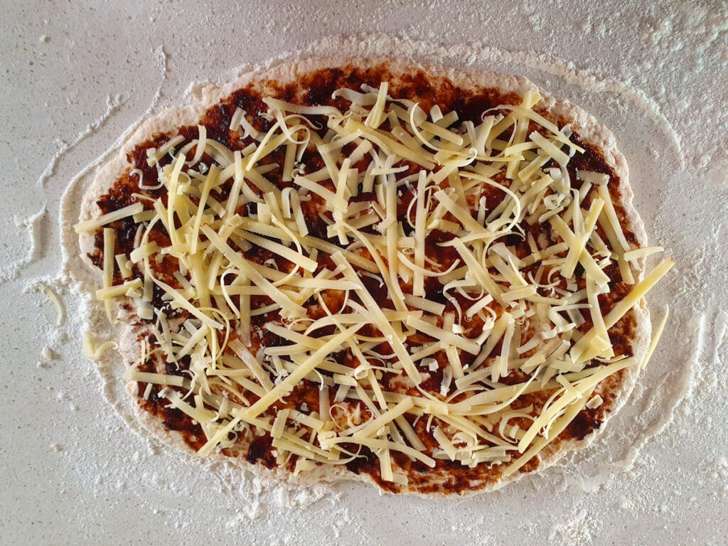 Cheesymite Scrolls 11 Dough with cheese sprinkled over the vegemite.