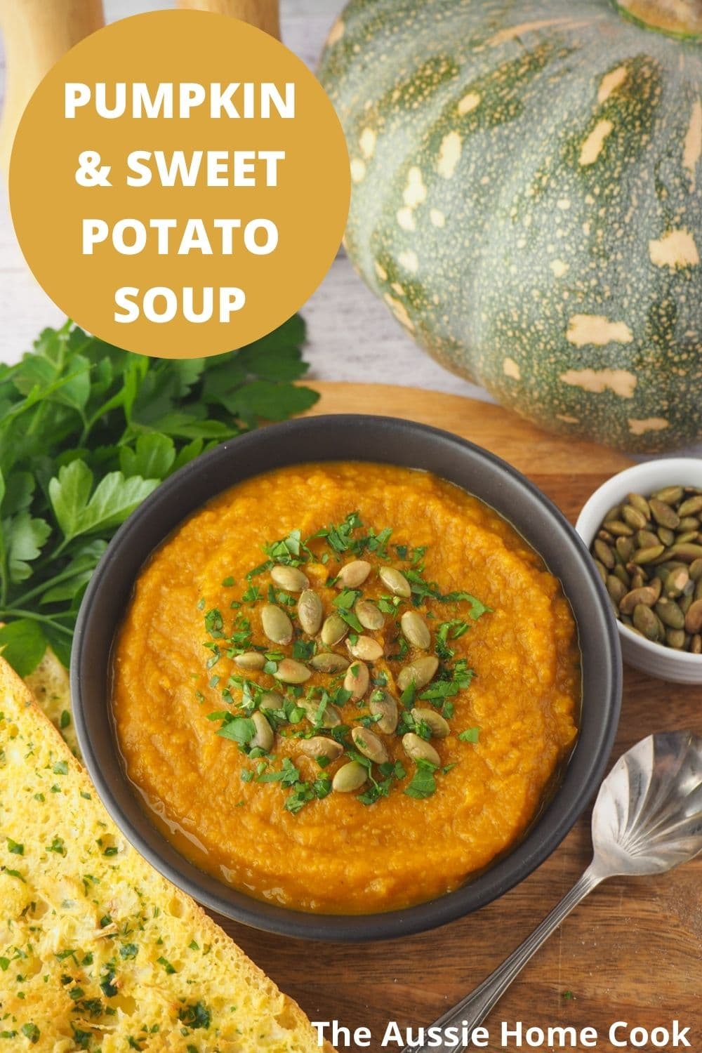Pumpkin and Sweet Potato Soup 21 Soup garnished with pumpkin seeds and parsley with spoon, garlic bread with text overlay, pumpkin and sweet potato soup and The Aussie Home Cook.