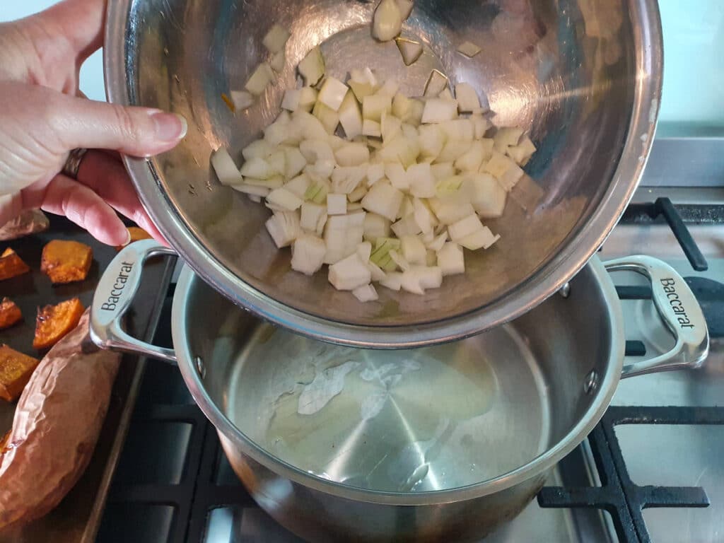 Pumpkin and Sweet Potato Soup 8 Adding onion to stock pot.