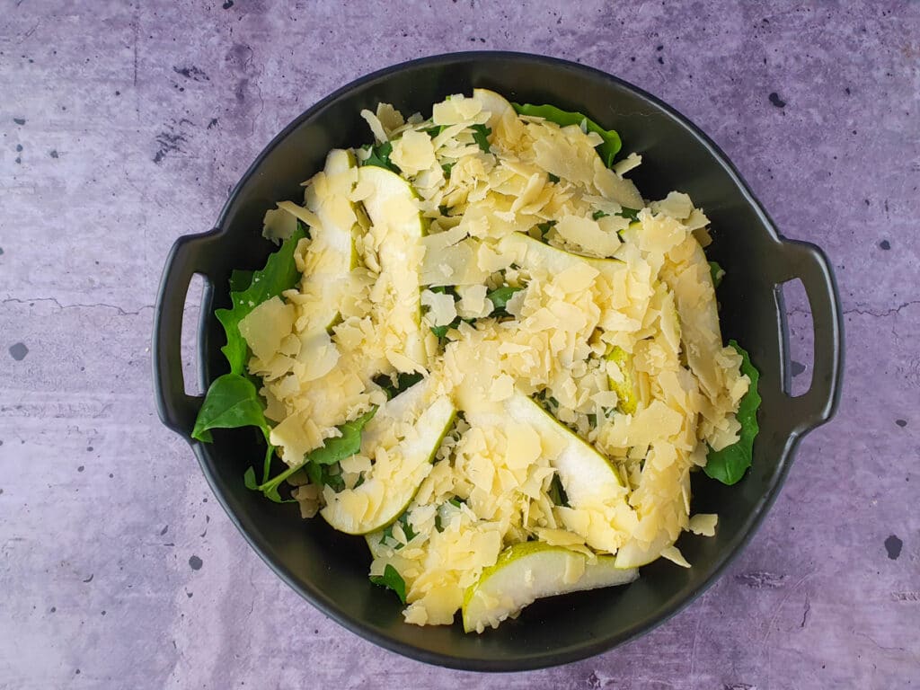 Building salad, adding shaved parmesan.