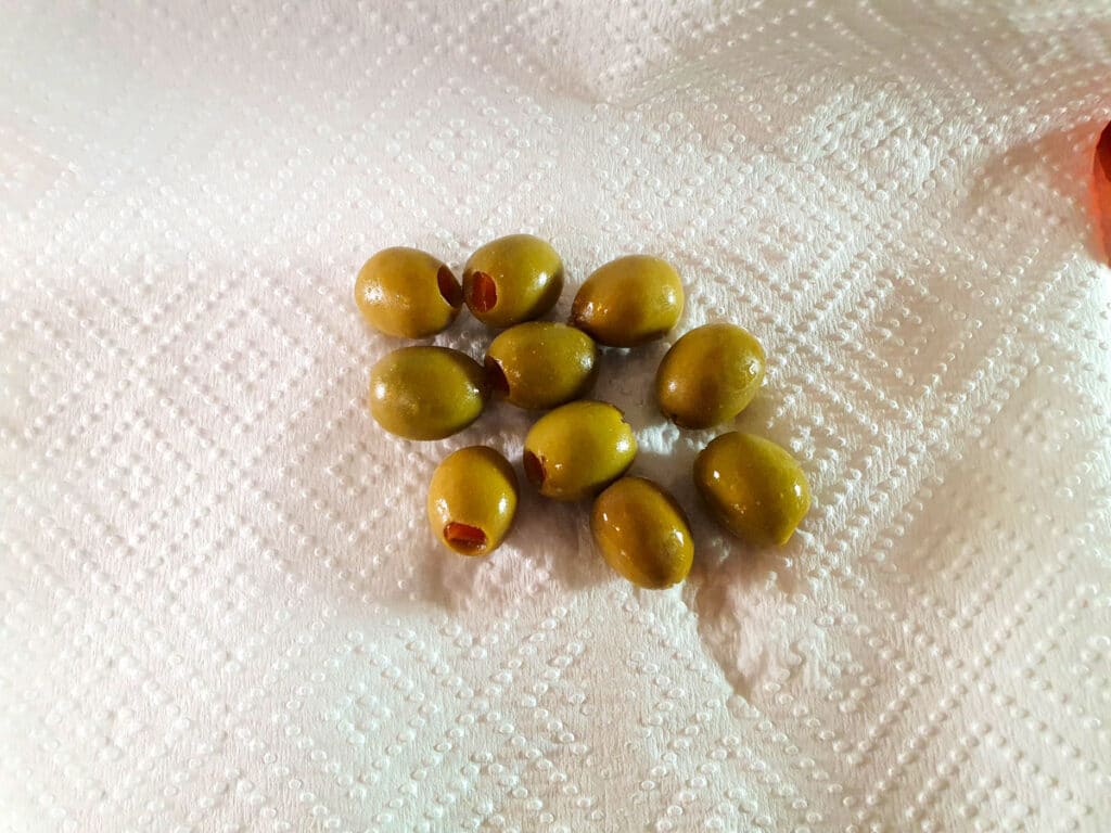 Picnic Charcuterie Board 5 Patting dry green olives.