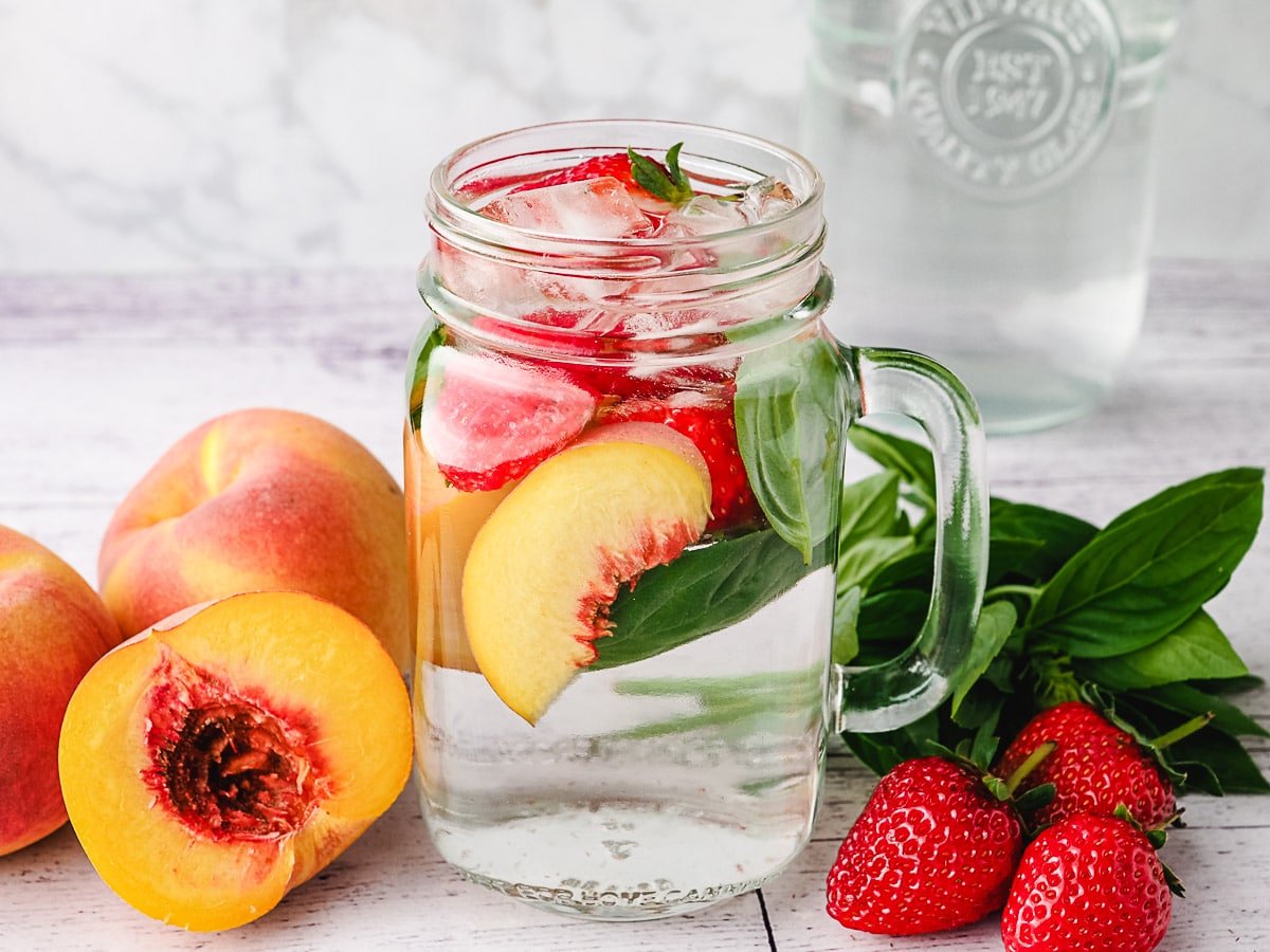 Peach Water 2 Peach infused water with strawberry and basil with fresh ingredients on the side.