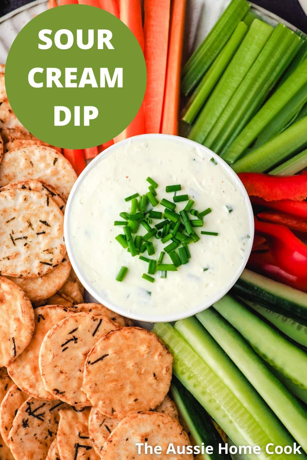 Sour cream dip with crackers and veggie sticks, celery, carrots, cucumber and red pepper.