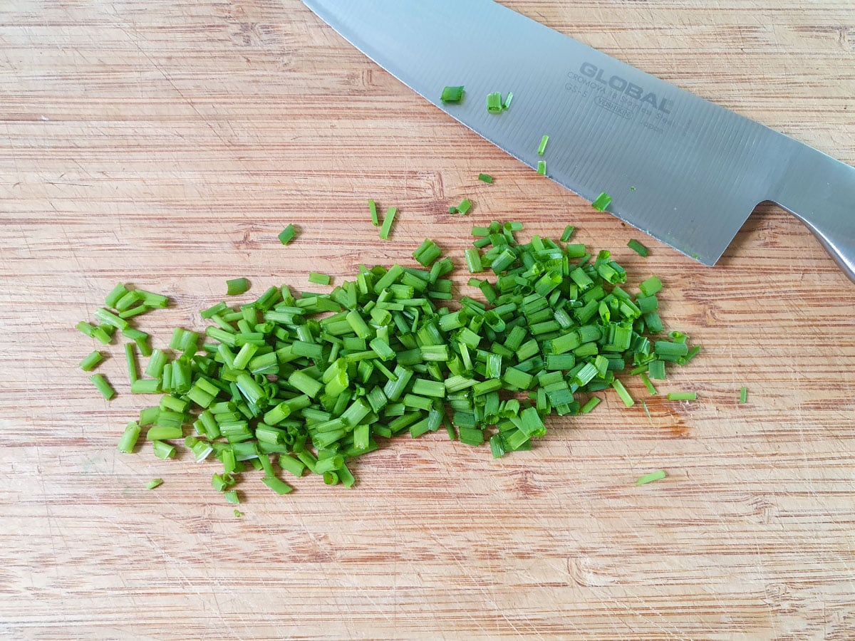 Finely chopping chives.